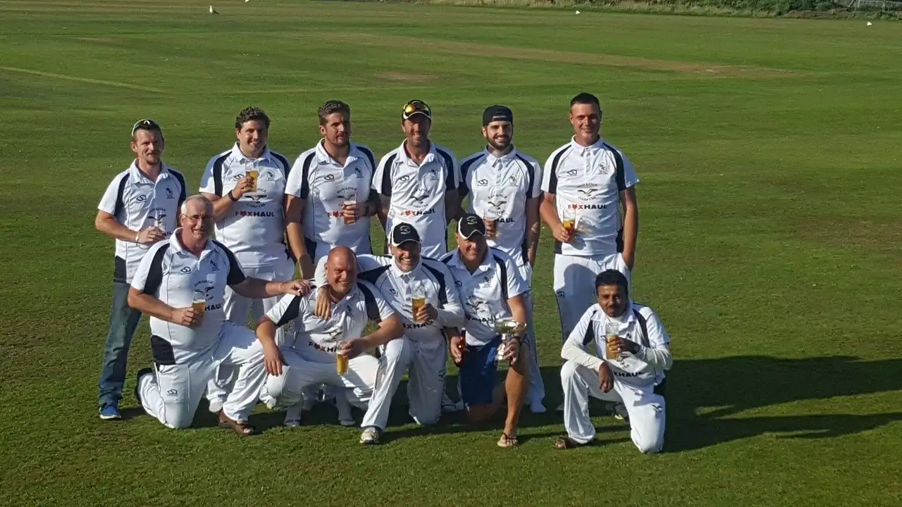 Hawkinge Cricket men's team with trophy in white polos